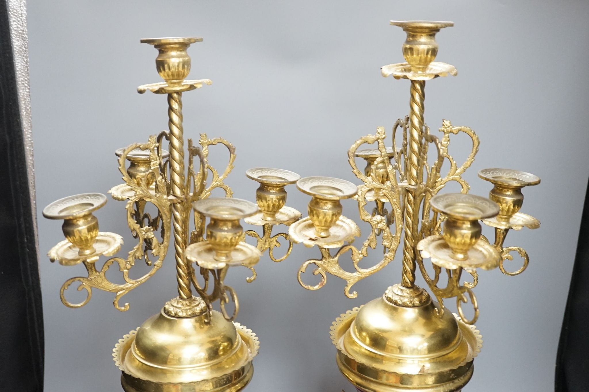 A pair of large brass and ceramic mounted candelabra, 64.5 cms high.